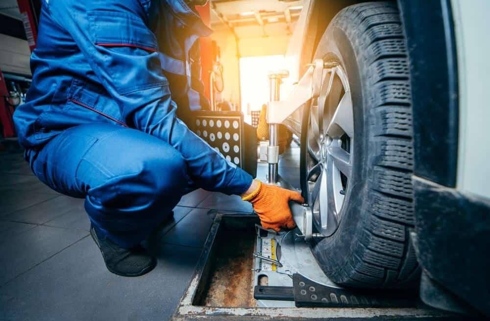 Mechanic rotates tire during tune up